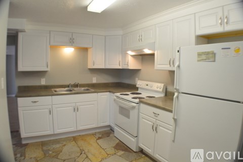 A kitchen with white cabinets and appliances.