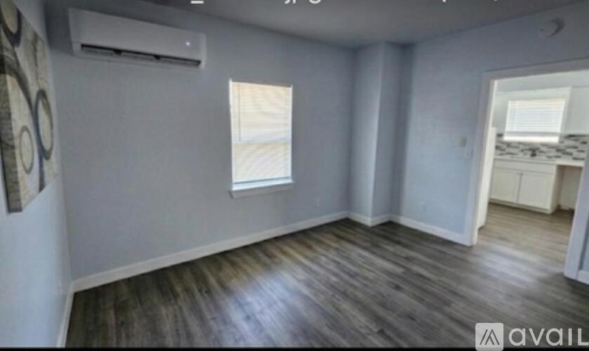 A room with wooden flooring and a window.
