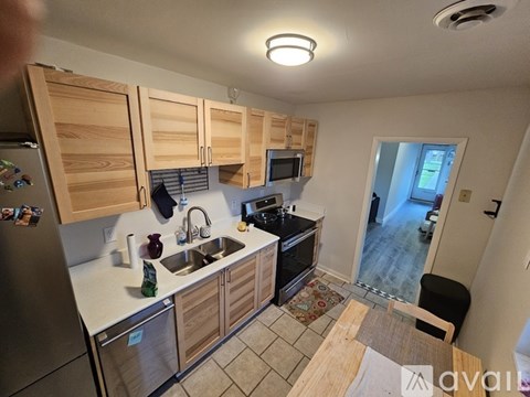 A kitchen with wooden cabinets and a stainless steel refrigerator.