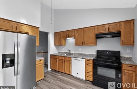 A kitchen with wooden cabinets and a black stove top oven.
