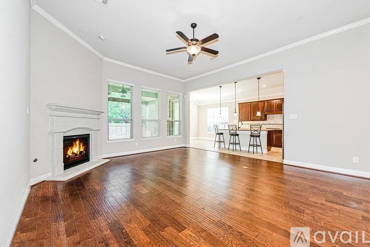 A spacious living room with wood flooring and a fireplace.