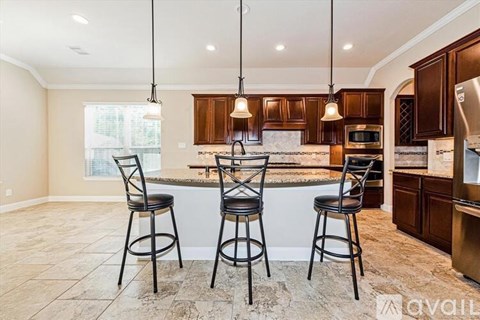A kitchen with a bar area featuring two stools.