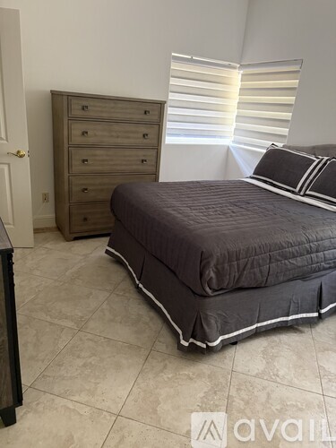 A bedroom with a bed, dresser, and nightstand.