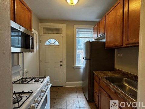 A kitchen with a stove, refrigerator, and microwave.