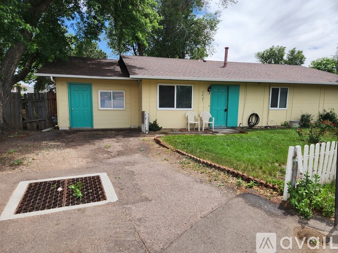 A house with a green door and a white picket fence.