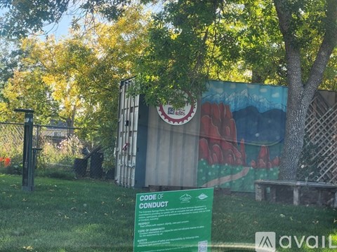 A green sign with the title Code of Conduct stands in front of a mural.