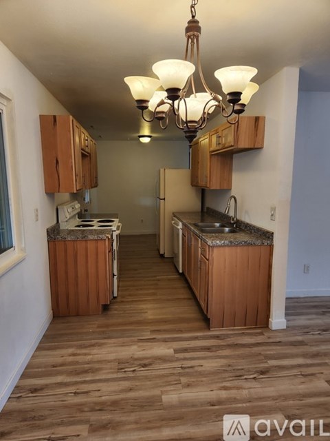 A kitchen with wooden cabinets and a chandelier.