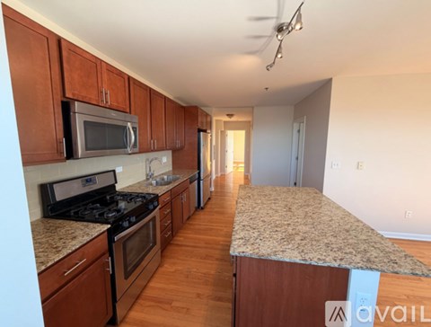A kitchen with brown cabinets and a granite countertop.