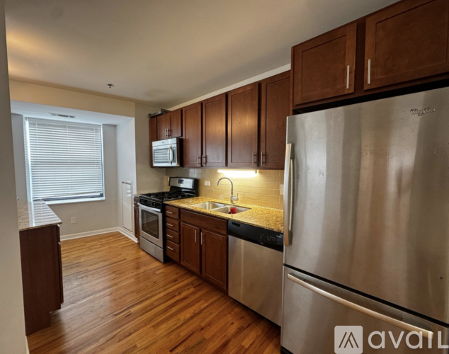 A kitchen with wooden cabinets and a stainless steel refrigerator.
