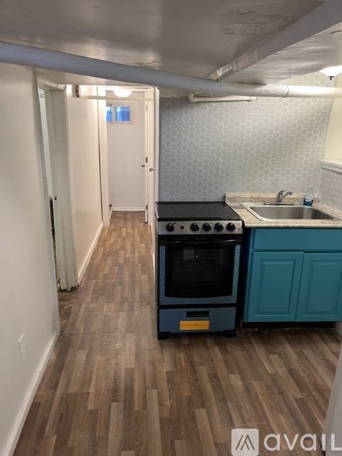 A kitchen with a black oven and a blue cabinet.