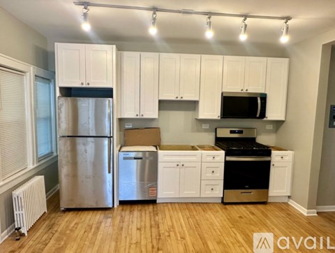 A kitchen with white cabinets and stainless steel appliances.