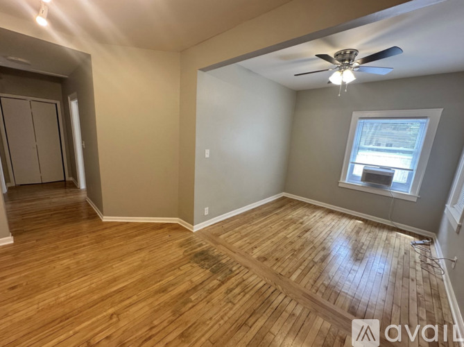 A room with wooden flooring and a ceiling fan.