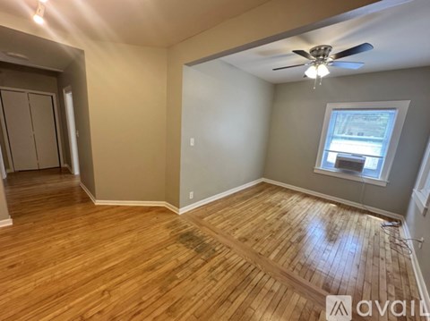 A room with wooden flooring and a ceiling fan.