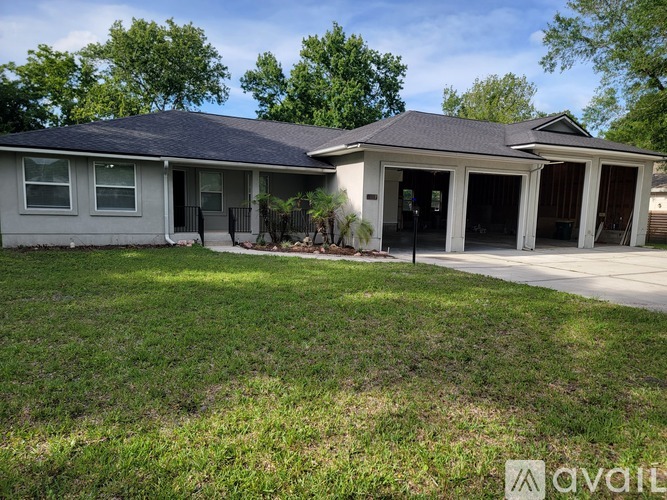 A house with a grey roof and a white garage door.
