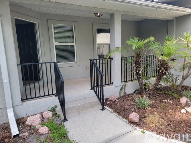 A house with a black railing on the porch.