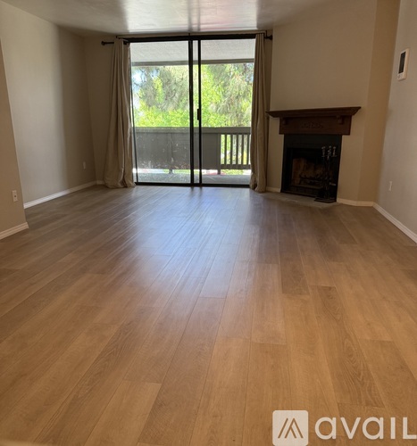 A room with wooden flooring and a fireplace.