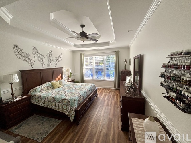 A bedroom with a bed, a ceiling fan, and a window with a view of the outside.