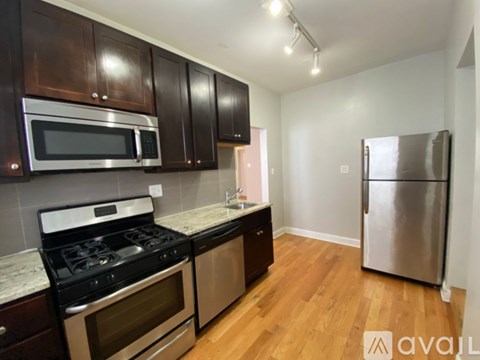 A kitchen with dark wood cabinets and stainless steel appliances.
