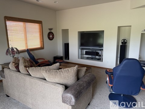 A living room with a couch, chair, and television.