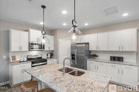 A kitchen with granite countertops and white cabinets.