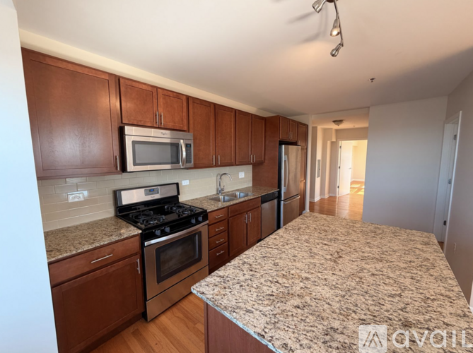 A kitchen with brown cabinets and a granite countertop.