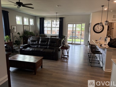 A living room with a black leather sofa and a wooden coffee table.