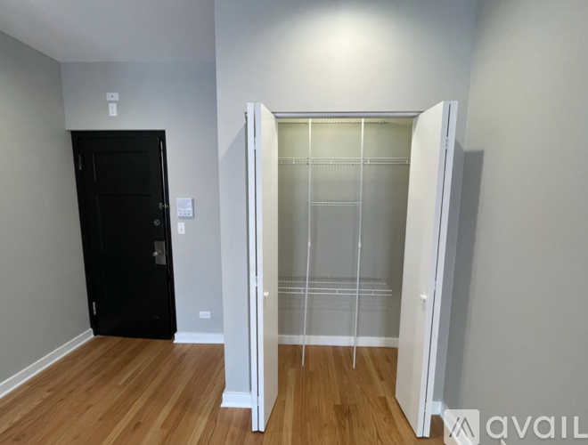 A room with a black door and a white door with a glass panel.