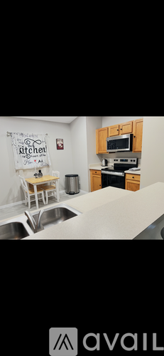 A kitchen with a sink, stove, and cabinets.