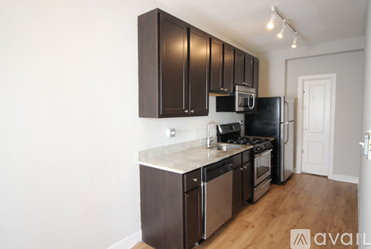 A kitchen with dark brown cabinets and stainless steel appliances.