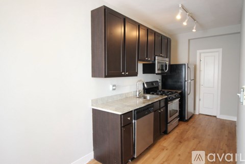A kitchen with dark brown cabinets and stainless steel appliances.