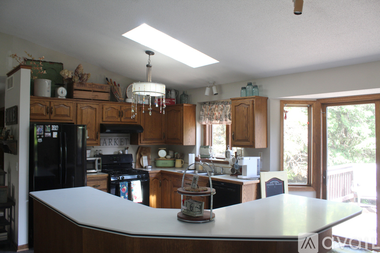 A kitchen with a white counter top and wooden cabinets.