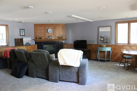 A living room with a grey couch and a fireplace.