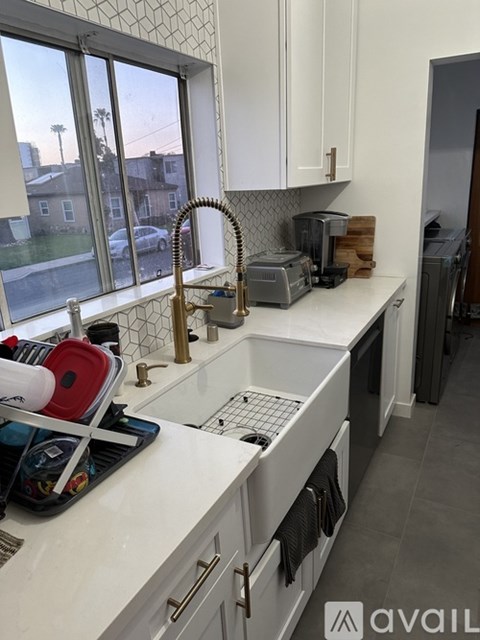 A kitchen with white cabinets and a white counter top.