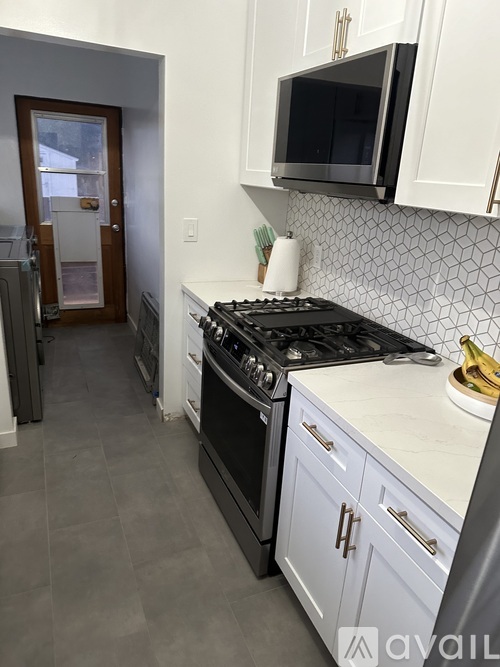 A kitchen with a black stove top oven and white cabinets.