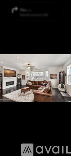 A modern living room with a large couch and a flat screen TV.