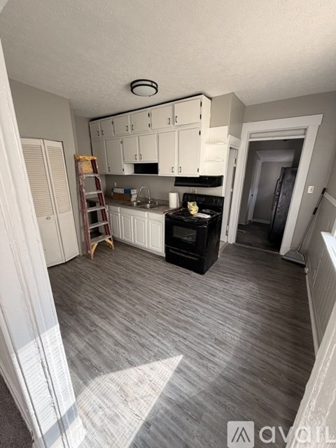 A kitchen with white cabinets and a black stove top oven.