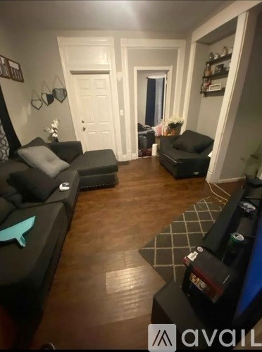 A living room with a black couch and a black chair.