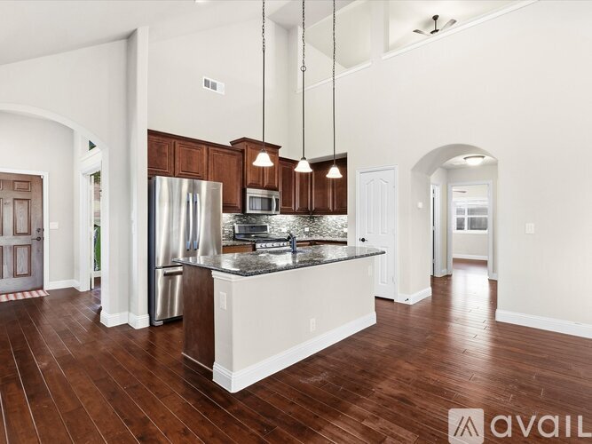 A kitchen with a refrigerator, microwave, and oven is available for rent.