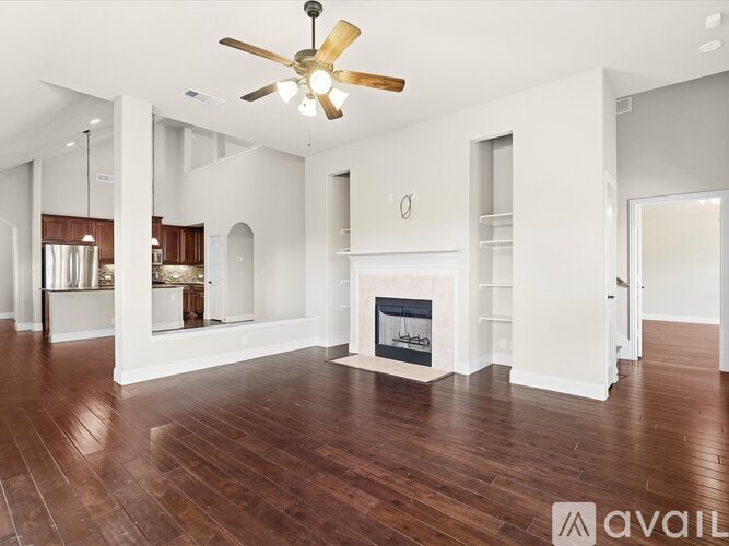 A spacious living room with a fireplace and hardwood floors.