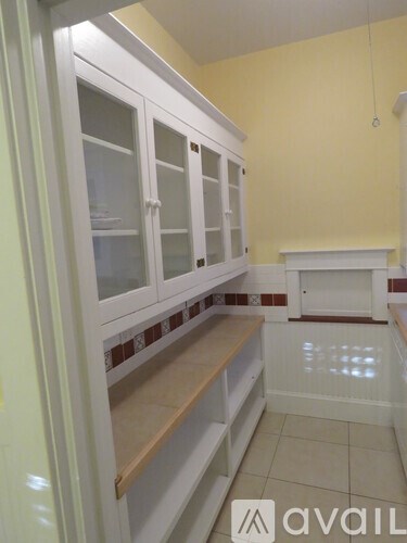 A kitchen with white cabinets and a fireplace.
