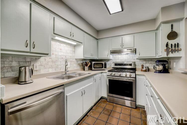 A kitchen with white cabinets and stainless steel appliances.