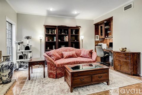 A living room with a red sofa and a wooden cabinet.