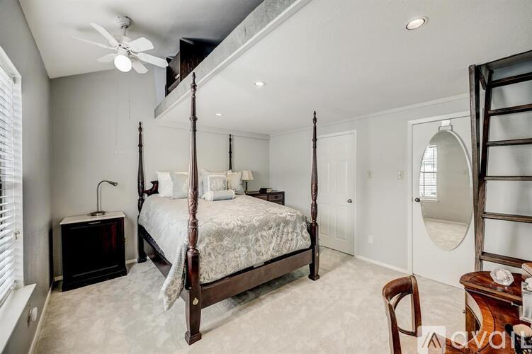 A bedroom with a four poster bed and a chair.