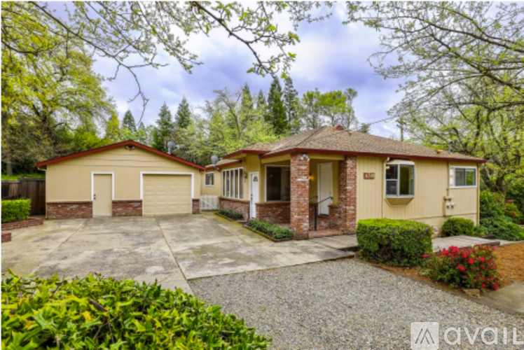 A house with a driveway and trees in the background.