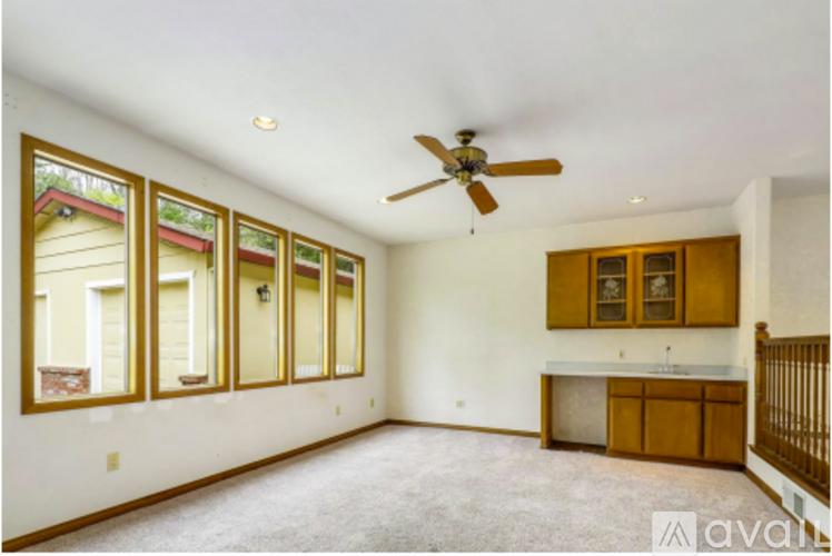 A spacious room with a ceiling fan and a cabinet.