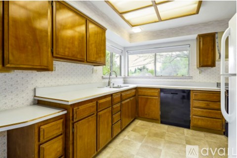 A kitchen with wooden cabinets and a tiled floor.