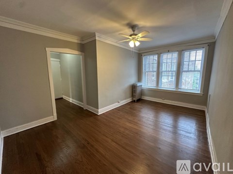A room with wooden floors and a ceiling fan.