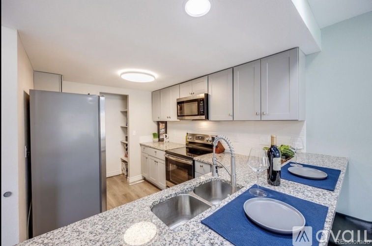 A kitchen with a granite countertop and stainless steel appliances.