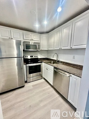 A kitchen with white cabinets and stainless steel appliances.