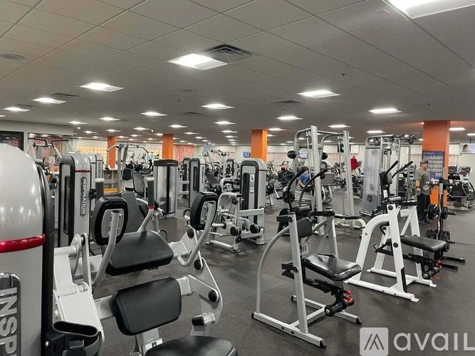 A gym with various exercise machines and weights.